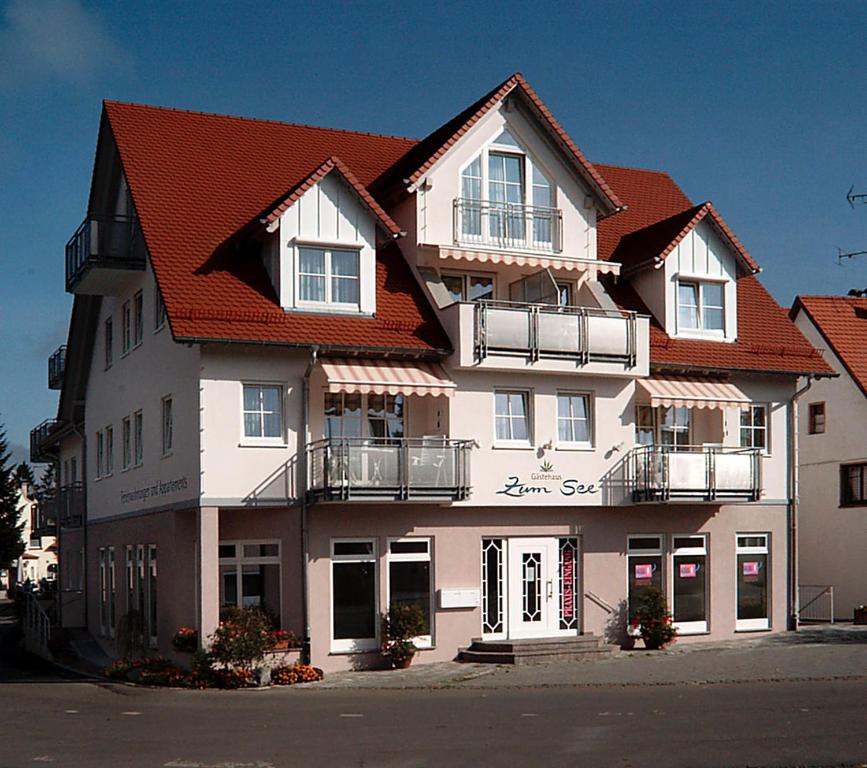 a large white building with a red roof at Gästehaus-zum-See in Bad Buchau