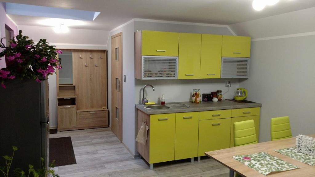 a kitchen with bright yellow cabinets and a table at Michałowice Noclegi u Anety in Michałowice