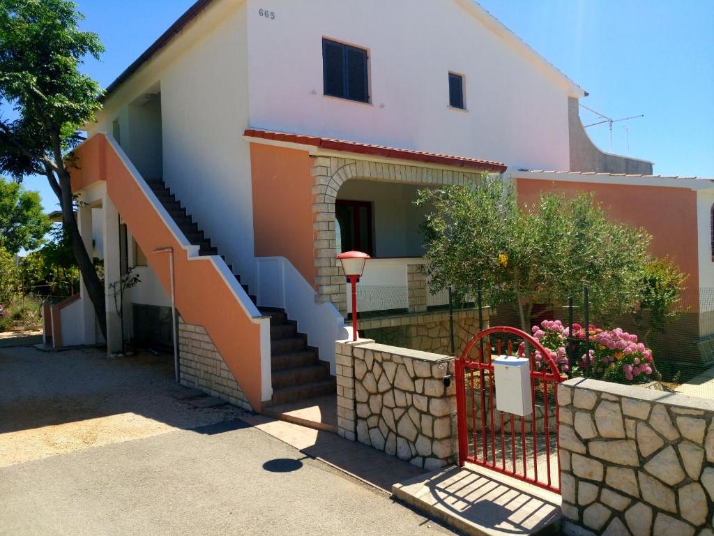 a house with a staircase in front of it at Apartmani Krunić in Barbat na Rabu