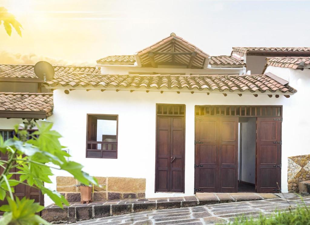 Una casa con dos puertas de madera. en Casa de Huéspedes Samuel en Barichara