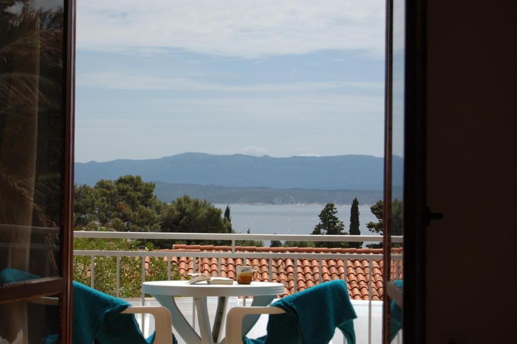 a table and chairs on a balcony with a view of the water at Barba Zoran in Bol