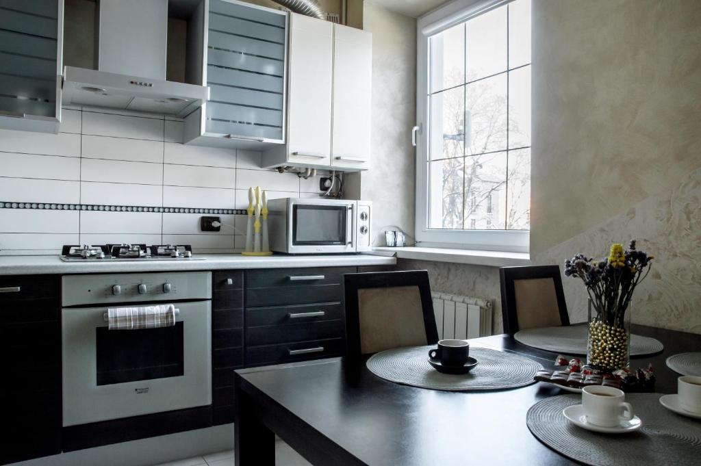 een keuken met een tafel en een fornuis top oven bij Old Town Apartments in Kamjanets-Podilsky