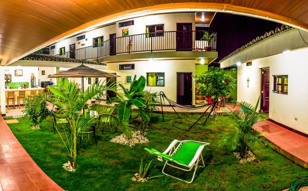 an indoor courtyard with a green chair in a building at Casa Lula León Hostal in León