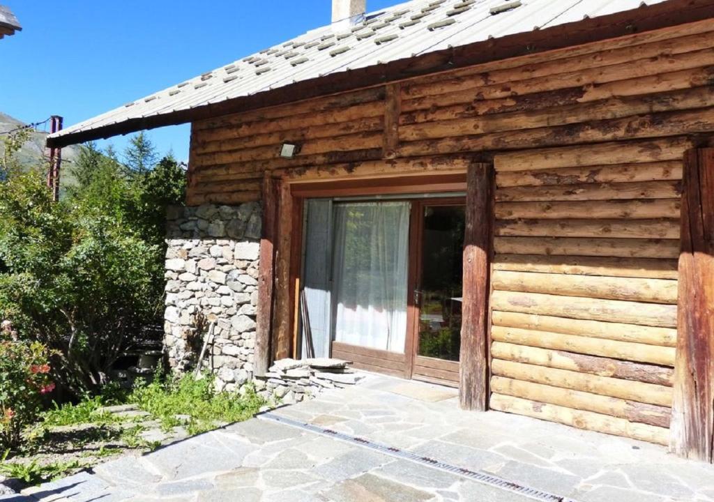 a log cabin with a large sliding glass door at La Balme in Puy-Saint-Vincent