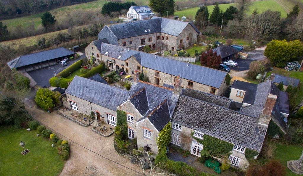 an aerial view of a large house with many roofs at Court Barton Farm in Aveton Gifford