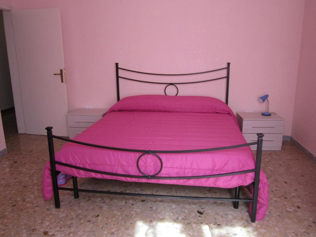 a pink bedroom with a bed with pink sheets at Casa Arcobaleno in Cupra Marittima