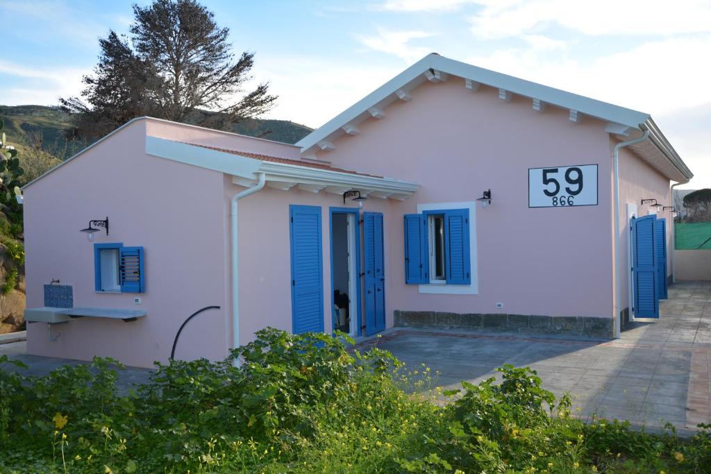チェファルにあるCasello villa sul mare a Cefalù 59+866の青いシャッター付き小さな白い家