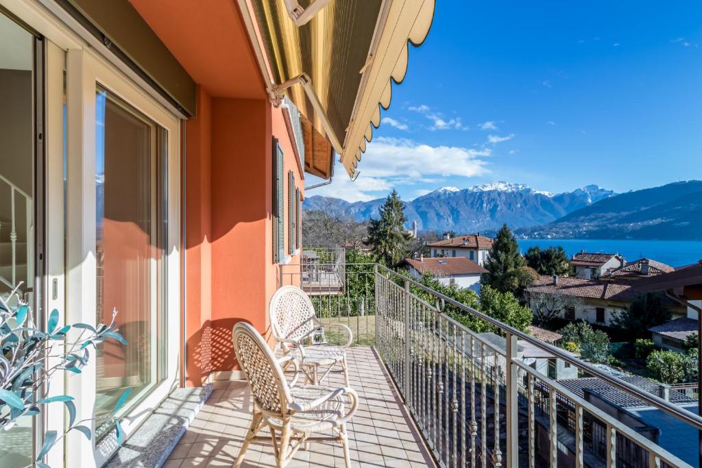 a balcony with chairs and a view of the mountains at Apartment Tulipani 17 in Tremezzo