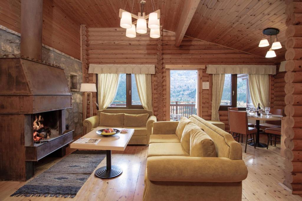 a living room with a couch and a fireplace at Xenios Chalet in &Aacute;no Kh&oacute;ra