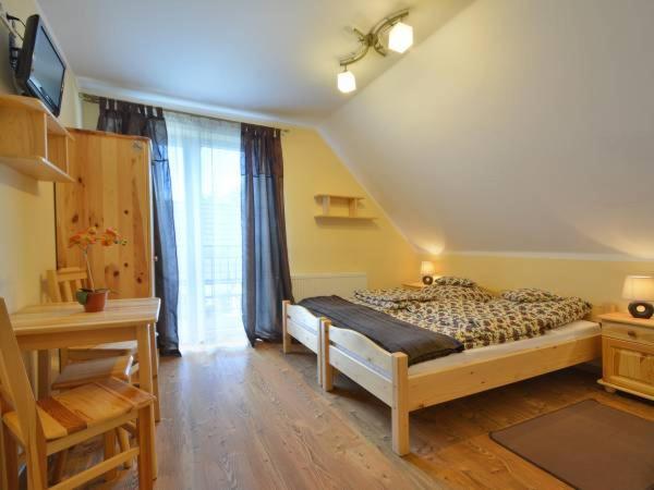 a bedroom with a bed and a desk and a television at Kamila in Szczawnica