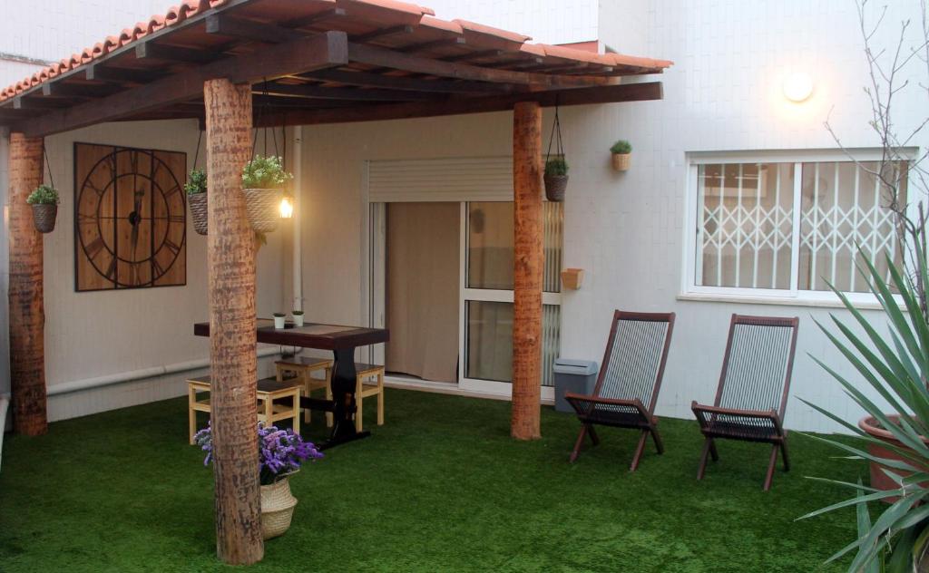 a patio with a wooden pergola and a table and chairs at Invicta Flats - Oporto in Porto