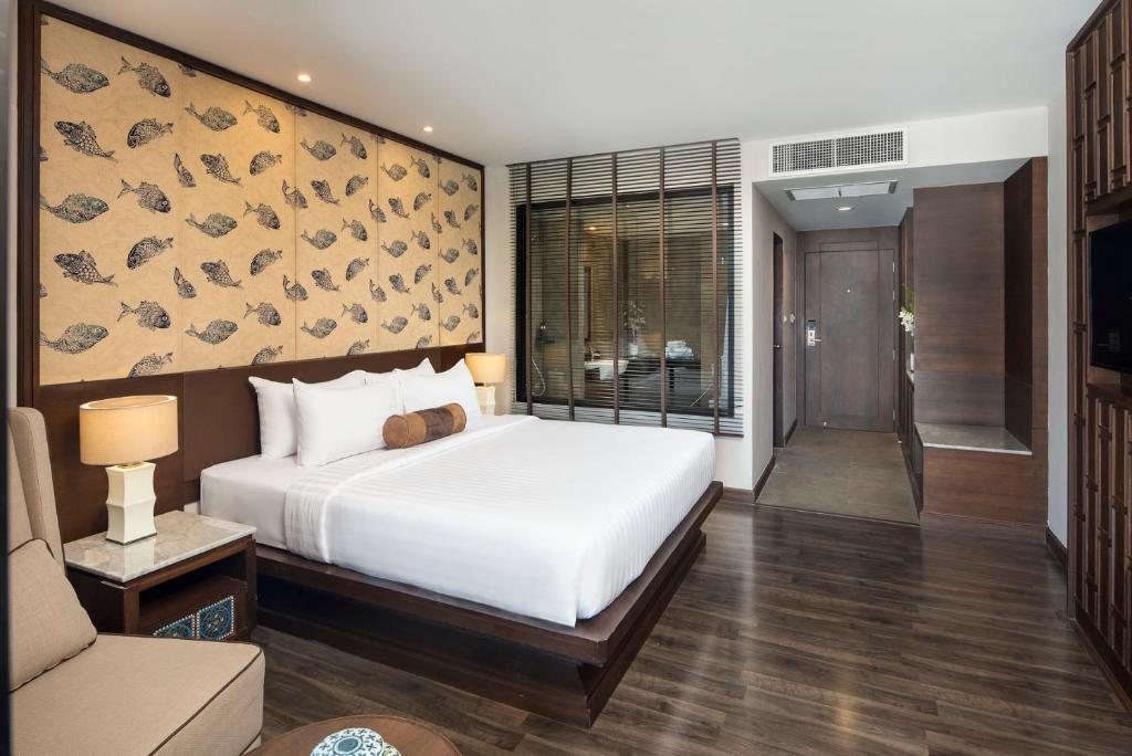 A large-bed room with a sofa, built-in storage, and a patterned feature wall.