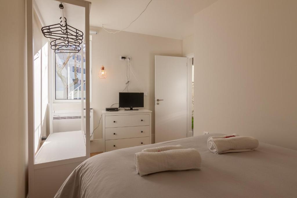 Habitación blanca con cama y ventana en Secret Camões, en Oporto
