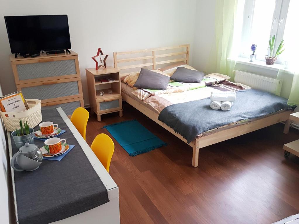 Apartament Bartolomeo Cheder في تورون: غرفة نوم بسرير وطاولة مع تلفزيون