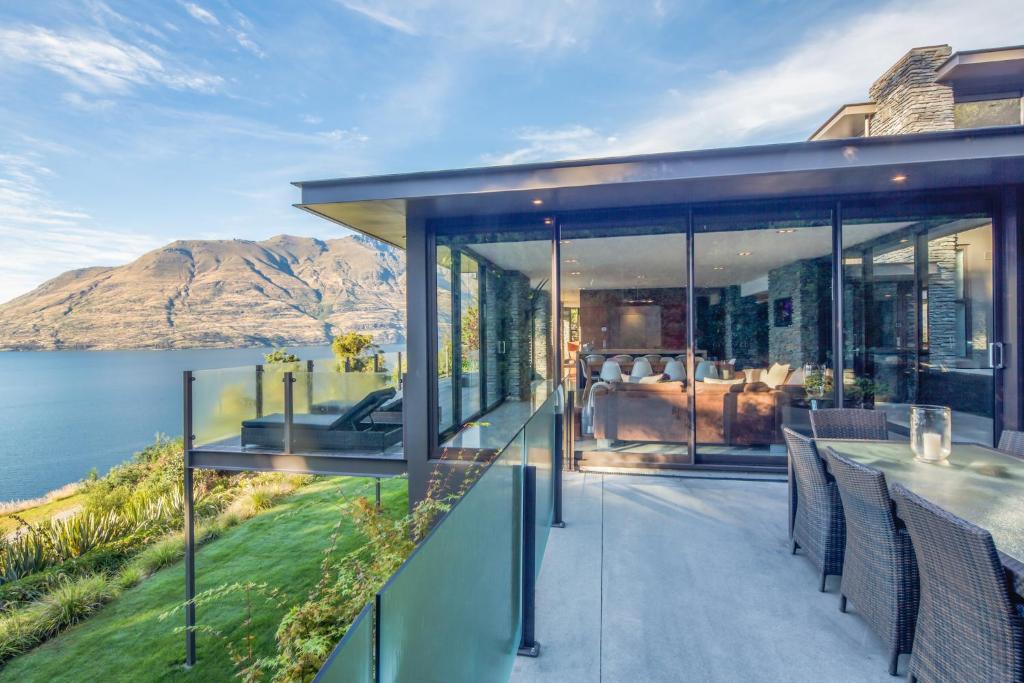 a glass house with a view of the water at Bellbrae Luxury Villa by MajorDomo in Queenstown