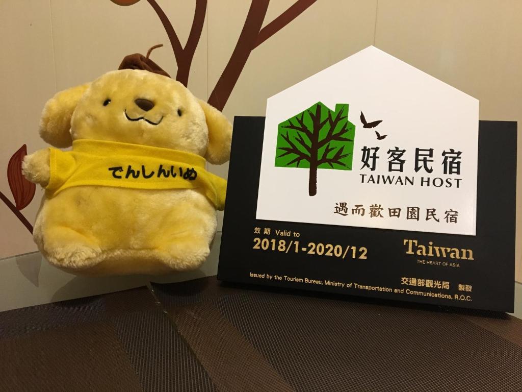 a teddy bear sitting next to a box at Yilan Real Fun Homestay in Dongshan