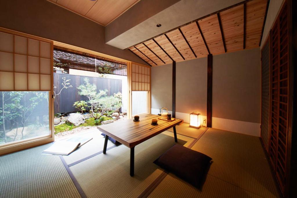 a room with a wooden table and a large window at sakainoma hotel 熊 in Sakai