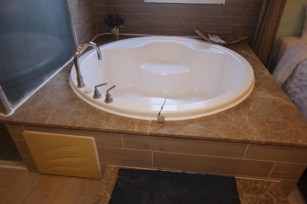a bath tub with a sink in a bathroom at Kenting Waterfront Hotel in Kenting