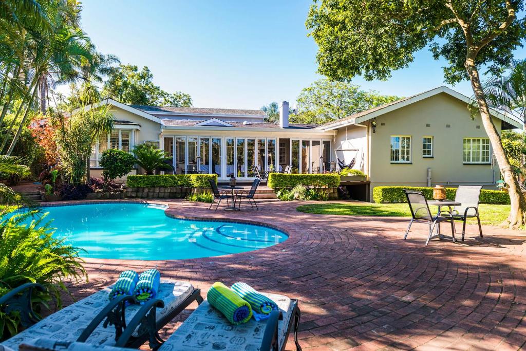 a house with a swimming pool in front of a house at Westville Bed and Breakfast in Durban