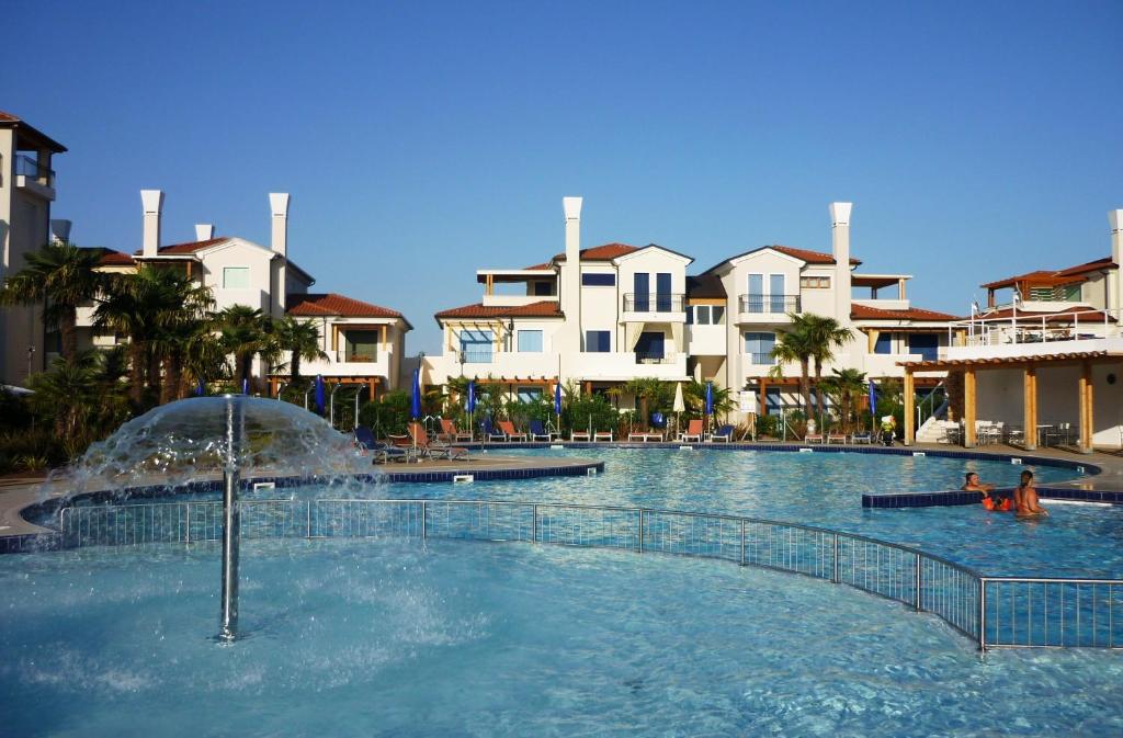 a swimming pool with a fountain in a resort at Villaggio A Mare in Caorle