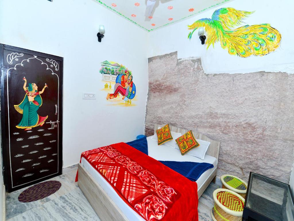 焦特布尔L G Guest House的卧室里有一张床，墙上挂着一幅画