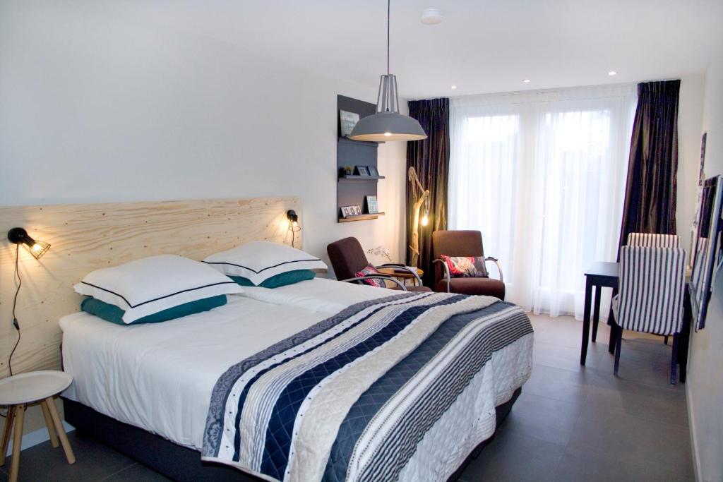 a bedroom with a large bed with a striped blanket at Studio-Vrij in Middelburg