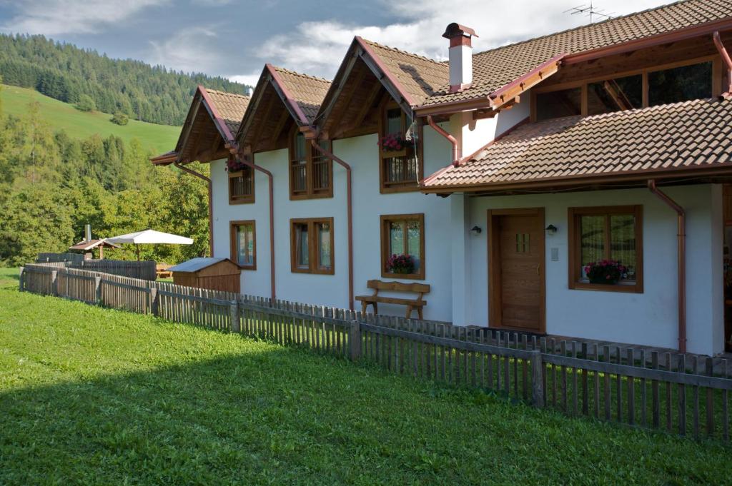 ein weißes Haus mit einem Zaun davor in der Unterkunft B&B Affittacamere Larix in Rumo