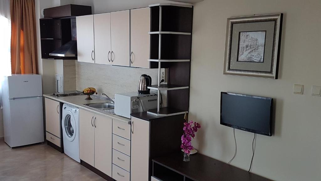a kitchen with a refrigerator and a tv in it at Tashevi Apartments in Pomorie
