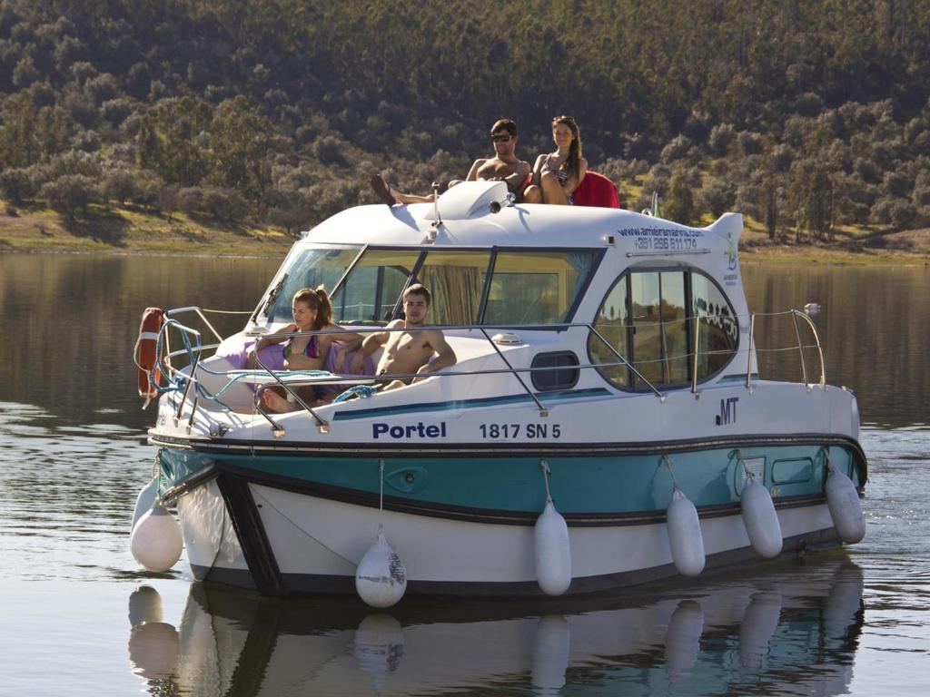 un grupo de personas sentadas en un barco en el agua en Amieira Marina, en Amieira