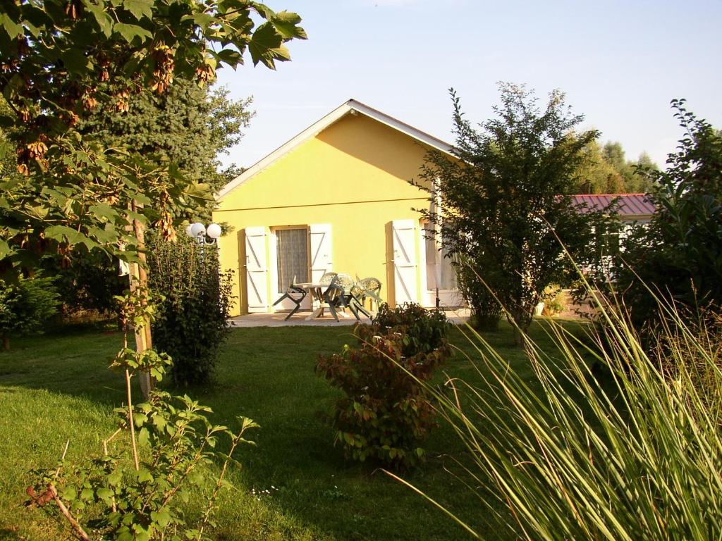 una casa amarilla con una mesa en un patio en Maison de MANON, en Illhaeusern