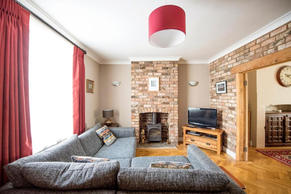 a living room with a couch and a fireplace at Georgian Terrace, Chester in Chester