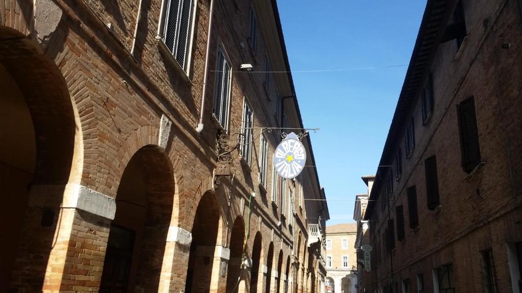 un orologio sul lato di un edificio di Albergo Italia a Urbino