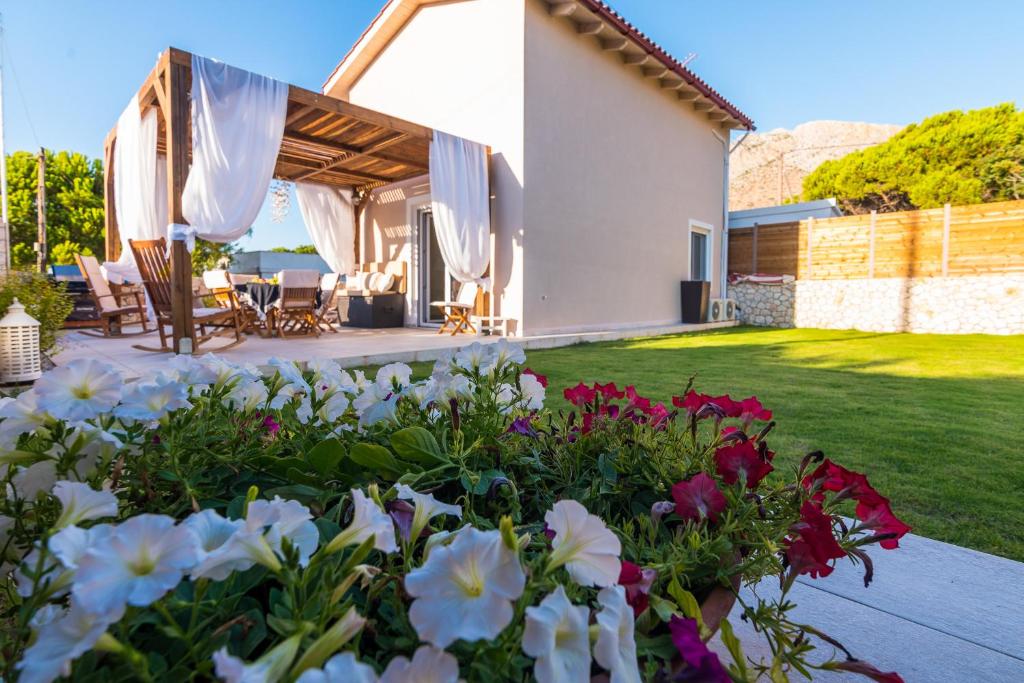 a house with a garden with flowers in the yard at Stavros Beach Garden Villa in Stavros