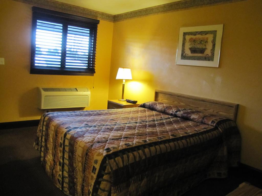 a bedroom with a bed and a window at Colonial Inn Mercer-Grove City in Mercer