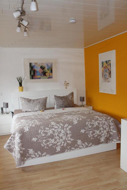 1 dormitorio con 1 cama grande y pared de color naranja en Ferienwohnung Spiegelberg en Spiegelberg