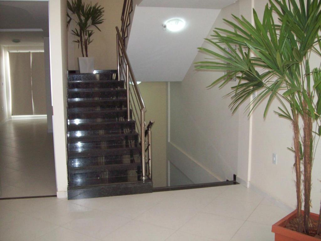 a staircase in a living room with palm trees at Hotel Milla in Teixeira de Freitas