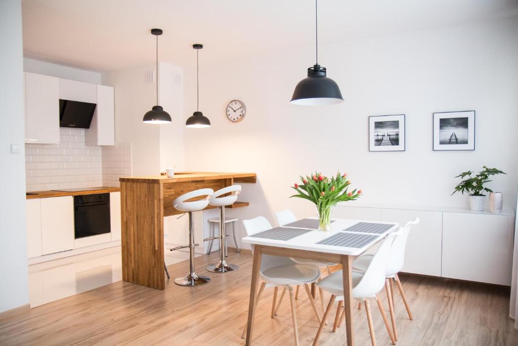 - une cuisine et une salle à manger avec une table et des chaises dans l'établissement Apartament F&J, à Toruń