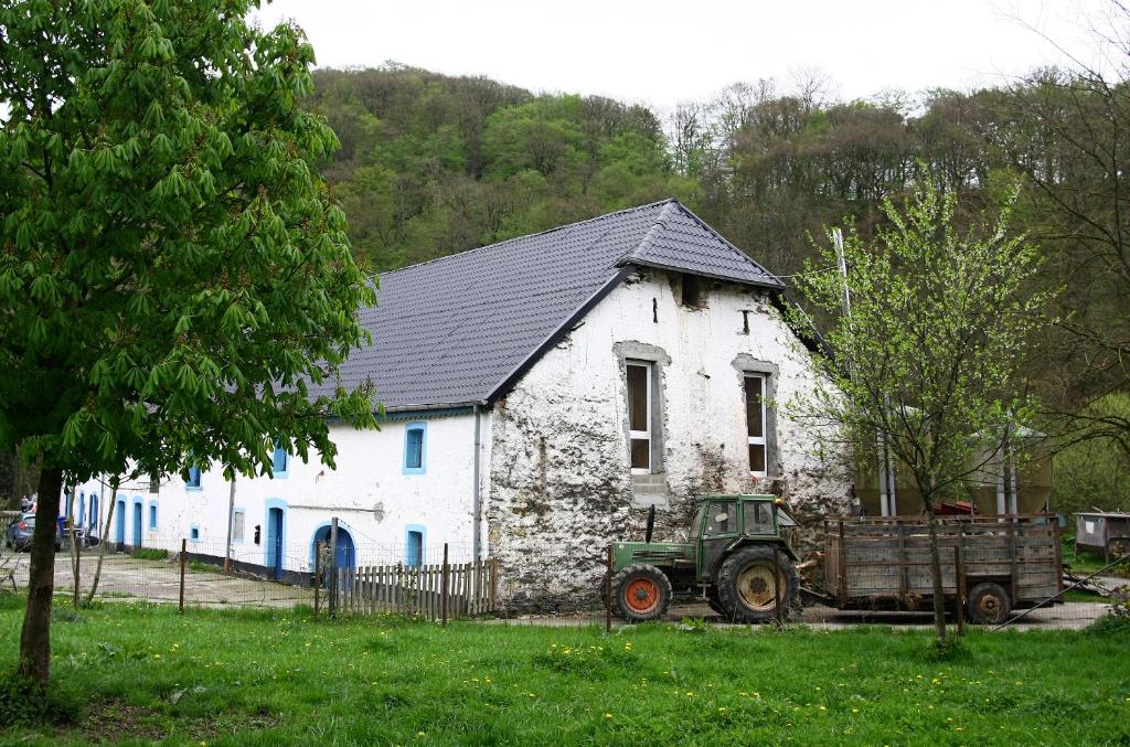 un tractor verde estacionado frente a un edificio blanco en B&B Berkel in old farmhouse en Bockholtz