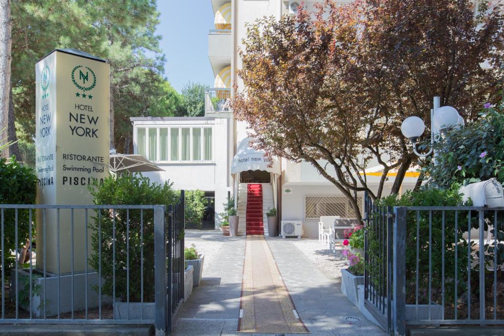 una puerta frente a un edificio con una señal de Nueva York en Hotel New York, en Cervia