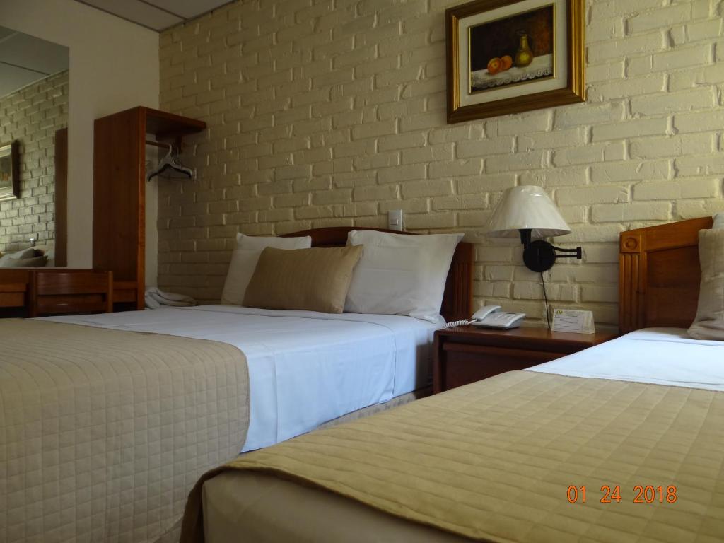 Ένα ή περισσότερα κρεβάτια σε δωμάτιο στο Hotel Mac Arthur