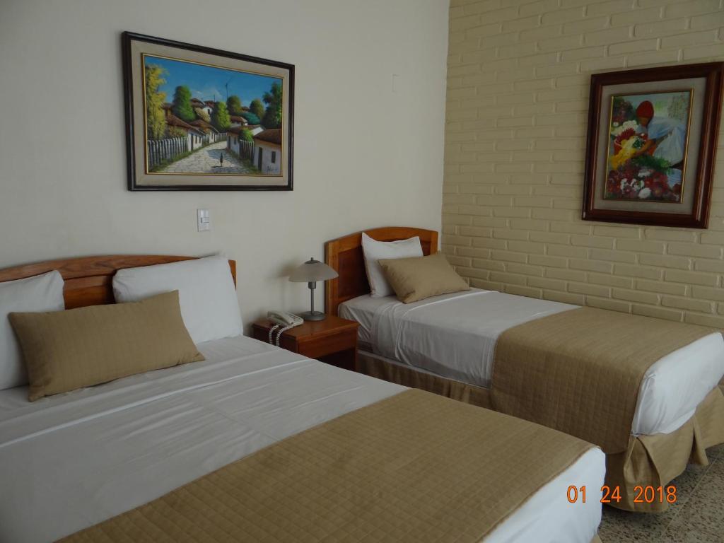 Ένα ή περισσότερα κρεβάτια σε δωμάτιο στο Hotel Mac Arthur