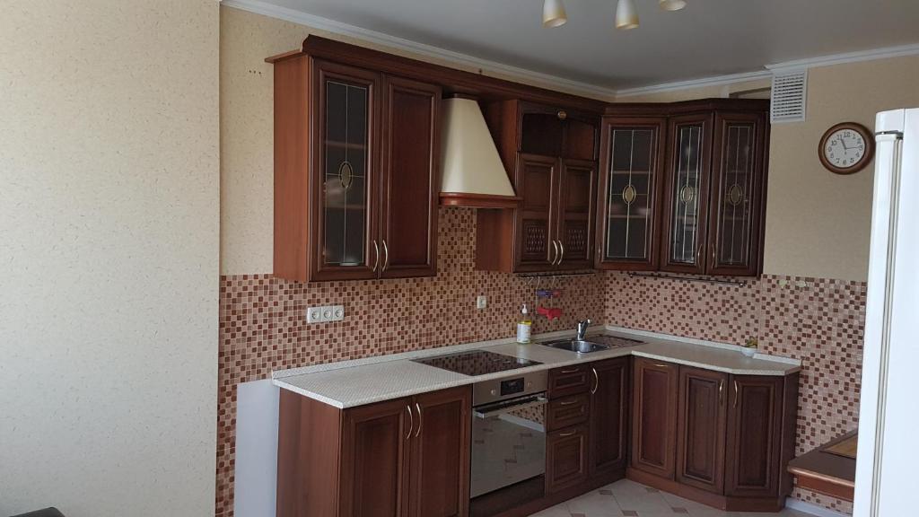a kitchen with wooden cabinets and a sink at Apartments Avrora, Gagarina 75 in Oryol