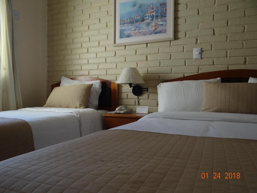 Ένα ή περισσότερα κρεβάτια σε δωμάτιο στο Hotel Mac Arthur