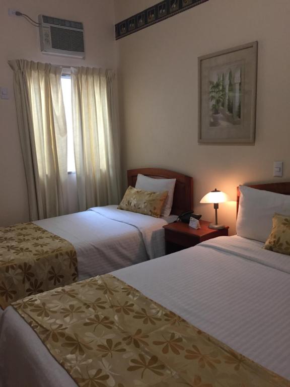 Ένα ή περισσότερα κρεβάτια σε δωμάτιο στο Hotel Mac Arthur