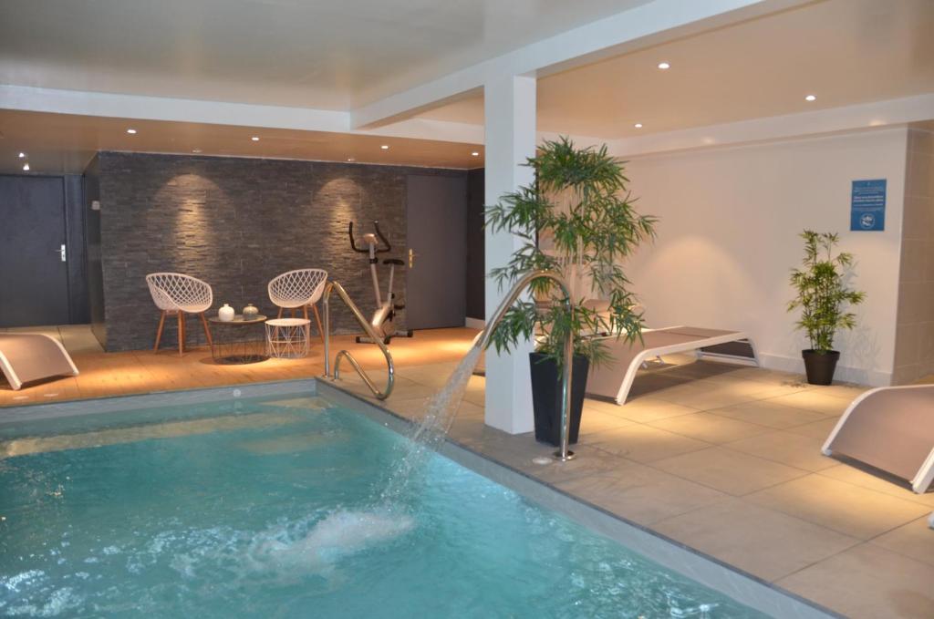 a room with a pool, a chair, and a tub in it at Hotel et Spa Les Cleunes Oléron in Saint-Trojan-les-Bains