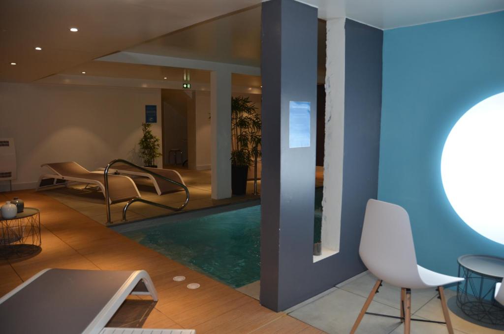 a lobby with a swimming pool in a building at Hotel et Spa Les Cleunes Oléron in Saint-Trojan-les-Bains