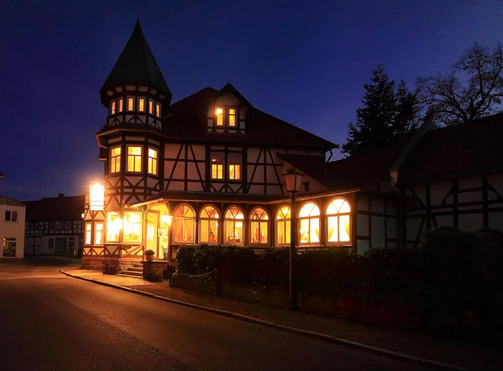 uma casa iluminada à noite com luzes em Gaststätte und Pension Felsenthal em Tabarz