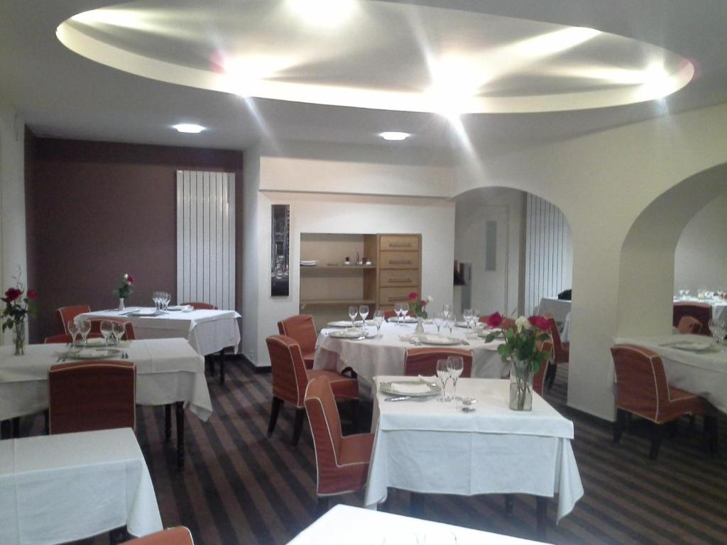 a dining room with white tables and chairs at Hotel les forges in Noyal-sur-Vilaine