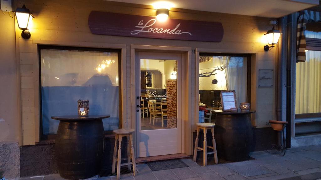 un ristorante con due sgabelli davanti ad una porta di La Locanda ad Asiago