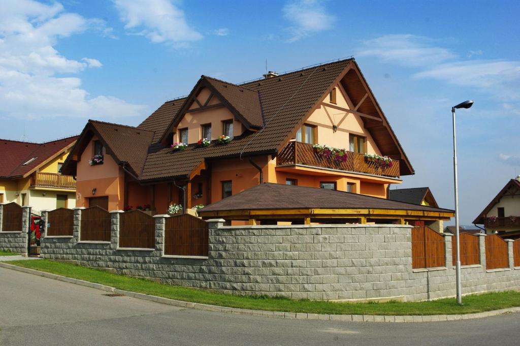 una casa con tetto marrone e muro di mattoni di Penzión Family Rušin a Veľká Lomnica